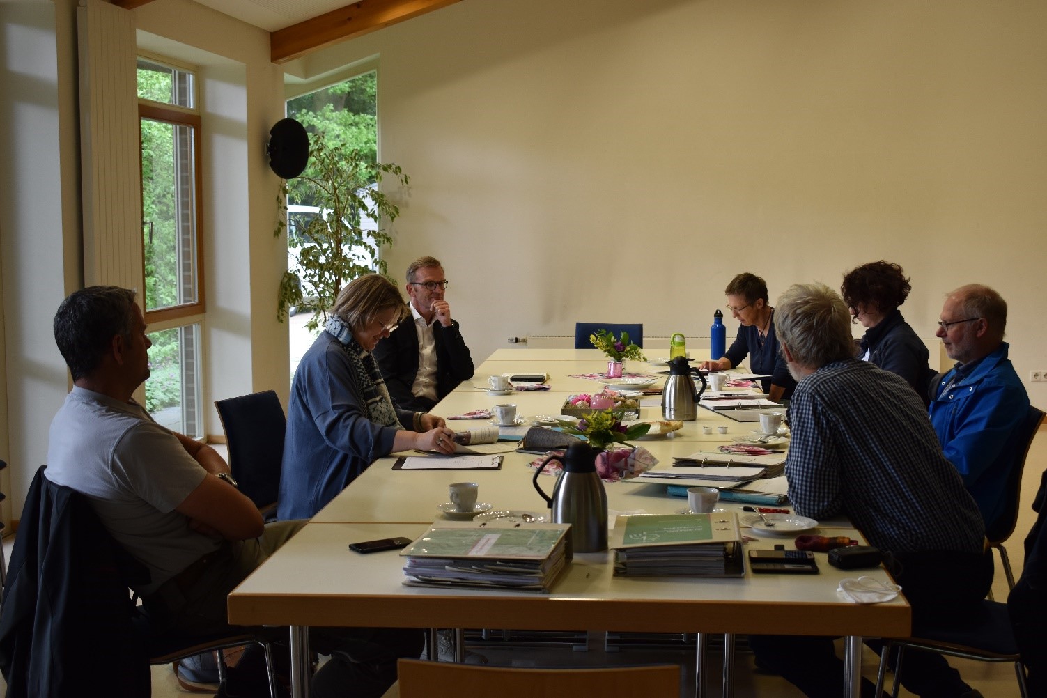 Besprechung mit mehreren Menschen an einem Tisch