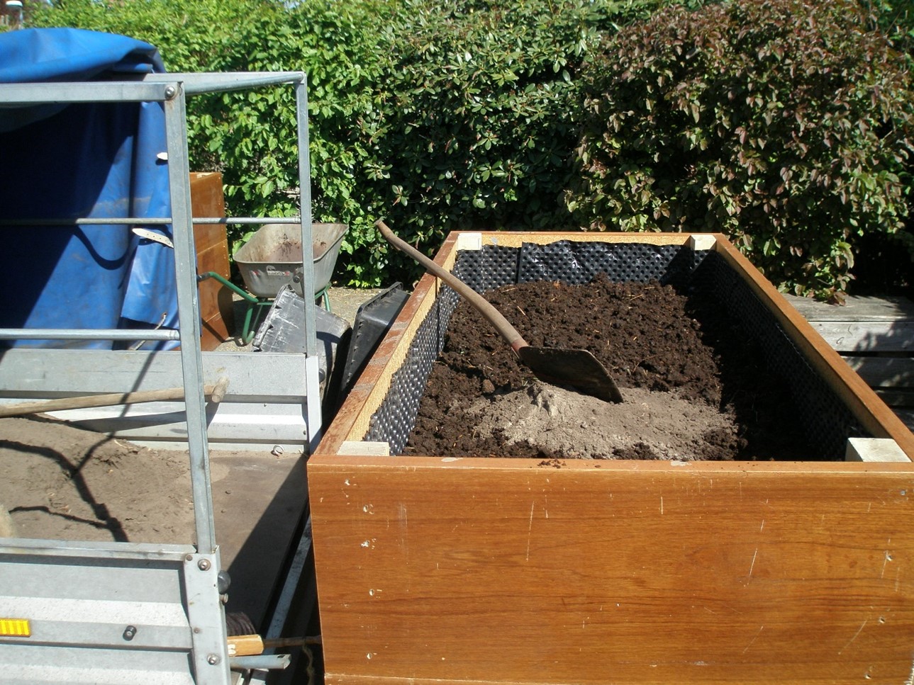 ein Hoclzkasten, der mit Erde gefüllt wird, um ihn später zu bepflanzen