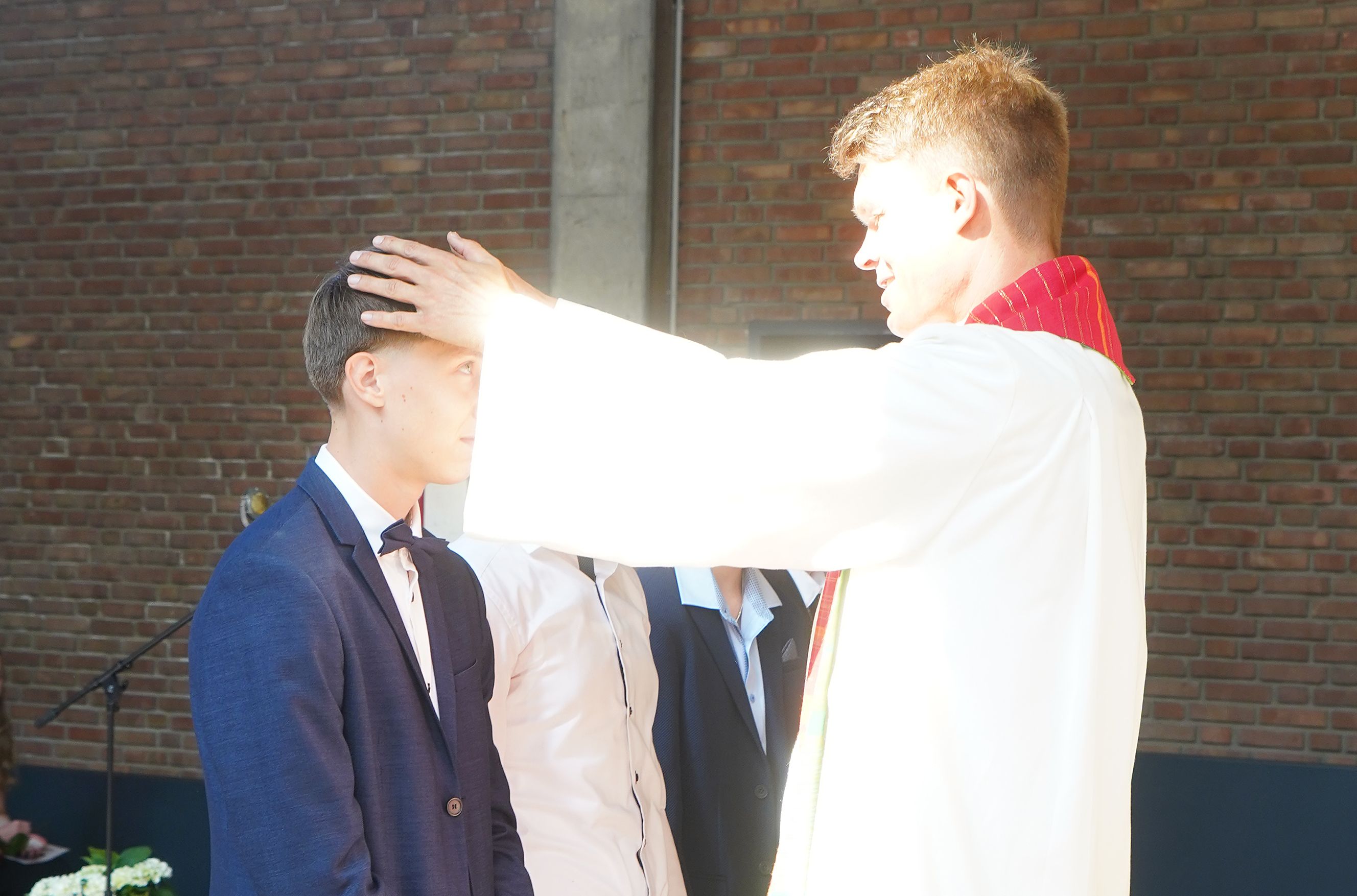 ein Pastor segnet einen Jugendlichen